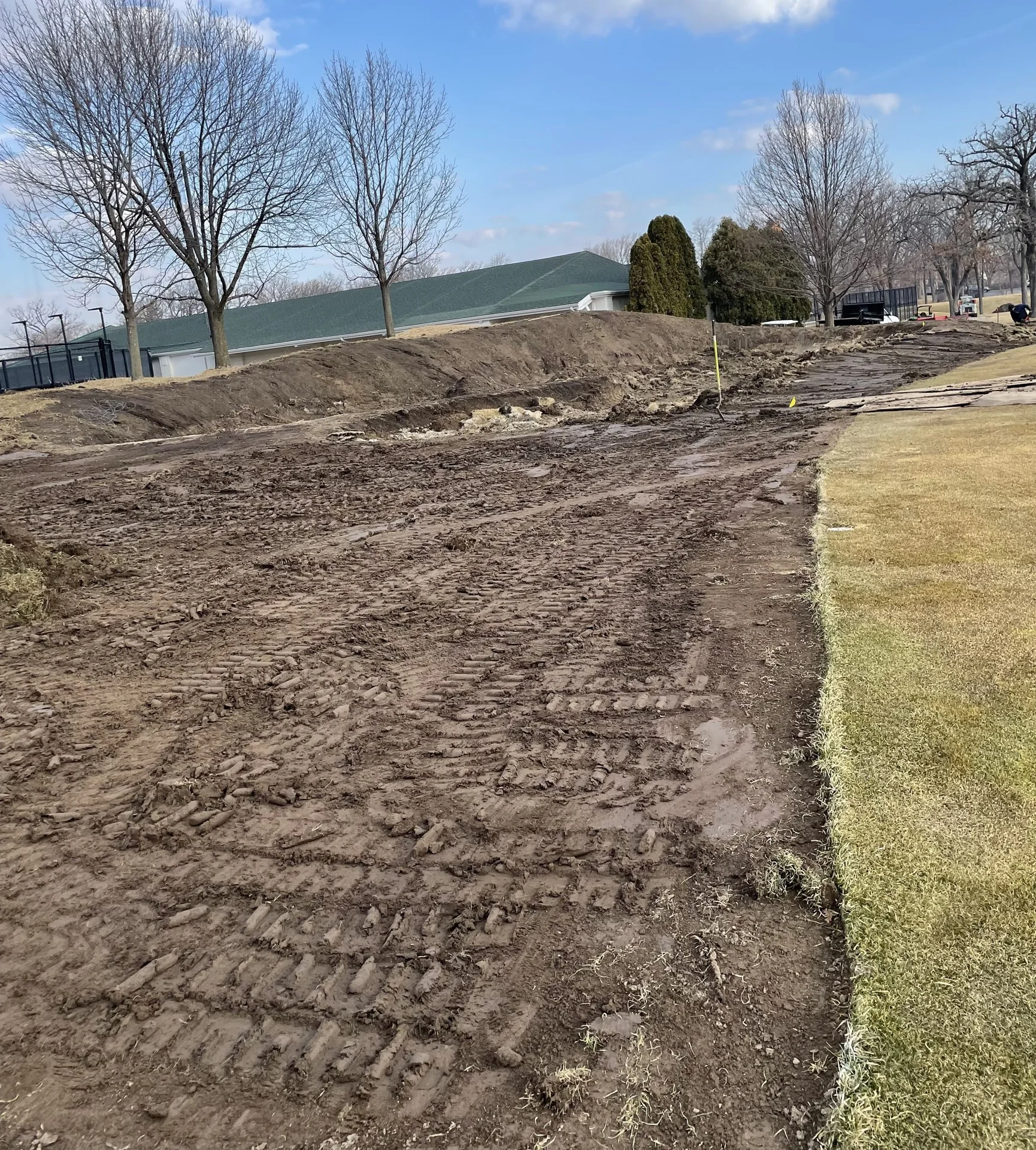 Golf course project area with exposed soil and adjacent turf